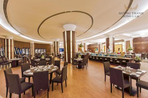 荣市孟清宋林奢华酒店的一间带桌椅和大型天花板的餐厅
