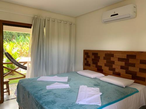 伊塔卡雷Pousada Villa Dos Sonhos的一间卧室配有带毛巾的床