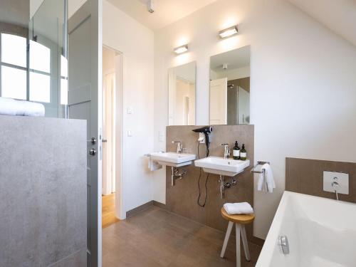 德兰斯克Reetland am Meer - Premium Reetdachvilla mit 2 Schlafzimmern, Sauna und Kamin E04的浴室设有2个水槽和2面镜子