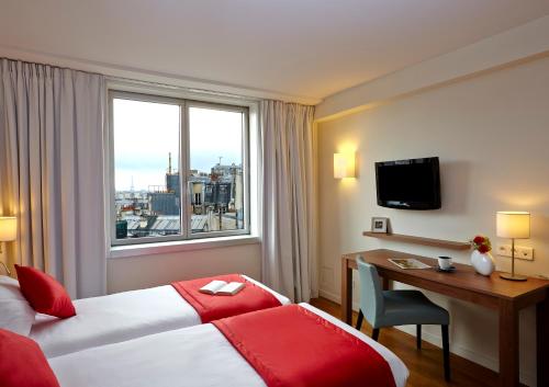 巴黎巴黎馨乐庭服务公寓意大利广场公寓式酒店的配有一张床、一张书桌和一扇窗户的酒店客房