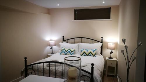 鲍内斯温德米尔Lowghyll suite的一间卧室配有一张带2个床头柜和2盏灯的床。