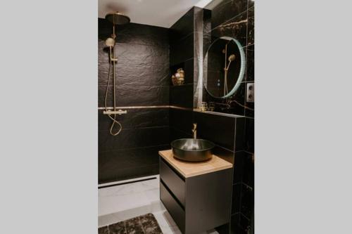 波普拉德APARTMENT A&D Downtown的黑色浴室设有水槽和镜子