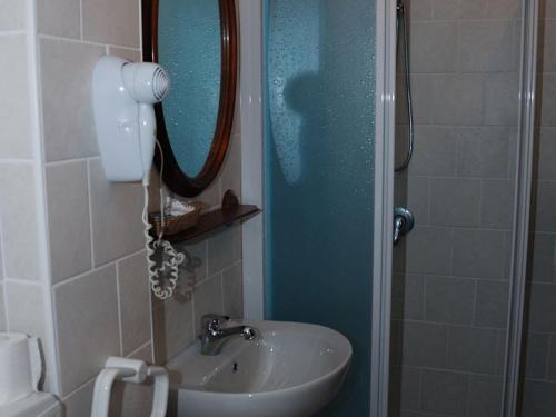 Taceno意大利餐厅萨西·罗西酒店的浴室配有盥洗盆和带镜子的淋浴