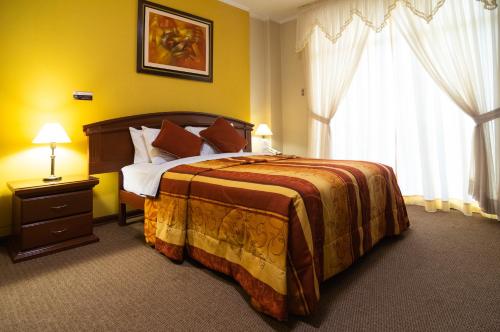 阿亚库乔赛拉利昂多拉达酒店的一间卧室设有一张大床和一个窗户。