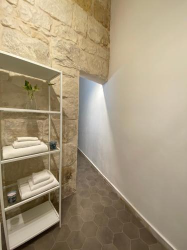 锡拉库扎Casa Maria的一间设有白色架子和石墙的浴室