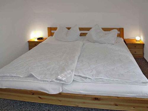 奥斯特西巴德钦诺维茨Holiday home in Zinnowitz (Seebad) 33031的一张配有白色床单和枕头的大床