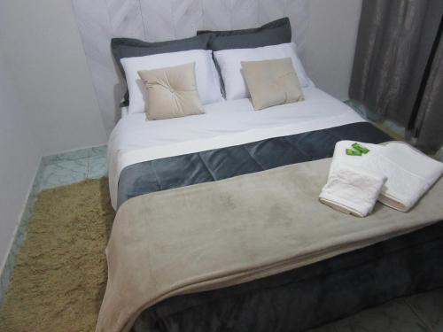 坎波斯杜若尔当Kitnet Recanto de Campos-Pertinho do Centro的一张大床,配有枕头和毛巾