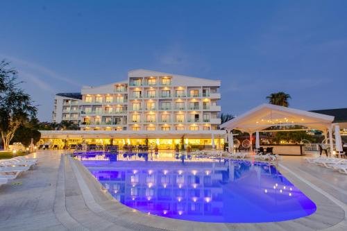 安塔利亚Falcon Hotel的夜间设有游泳池的酒店