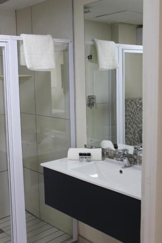 昆斯敦Luxe-Molen Boutique Hotel的浴室配有白色水槽和淋浴。