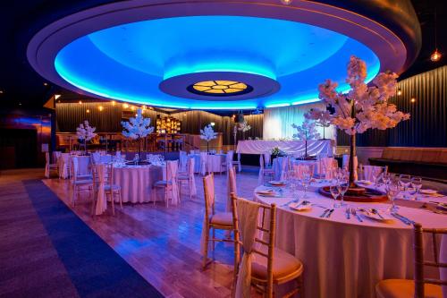 邓多克邓多克皇家酒店的一间舞厅,配有白色的桌椅和蓝色的天花板