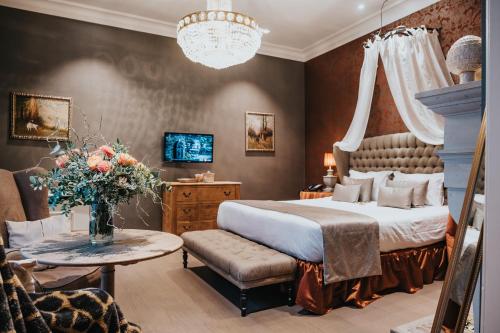布鲁日Boutique Hotel De Castillion - Small elegant family hotel的一间卧室配有一张床和一张花瓶桌子