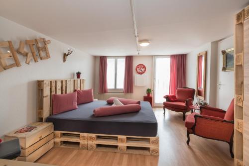 因特拉肯Balmers Hostel的一间卧室配有一张大床和两把椅子