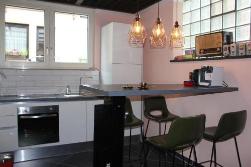 费尔巴赫BLUE SKY-Suite的厨房配有柜台和一些椅子