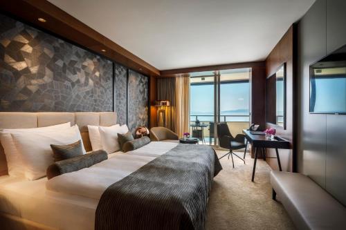 奥帕提亚Hotel Ambasador - Liburnia的酒店客房设有一张大床和一张书桌。