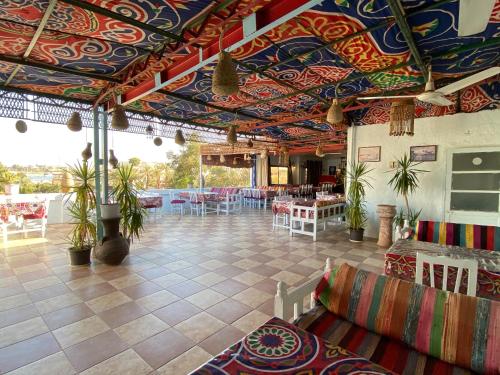 卢克索厄尔尼诺杰济拉酒店 的餐厅拥有色彩缤纷的天花板和桌椅