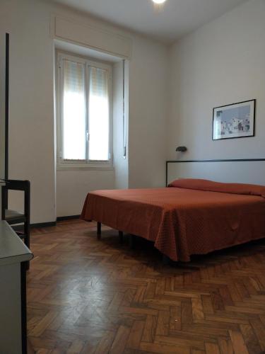阿拉西奥Affittacamere Giannina的一间卧室设有一张床和一个窗户,铺有木地板