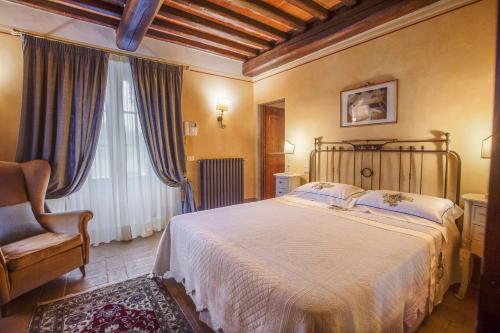 圣吉米纳诺Tenuta Guardastelle - Agriturismo and vineyard的卧室配有床、椅子和窗户。