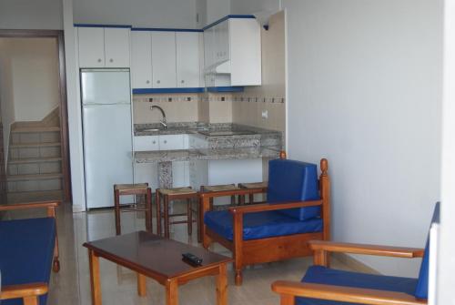 拉雷斯廷加Apartamentos Los Saltos的厨房配有蓝色的椅子、桌子和柜台