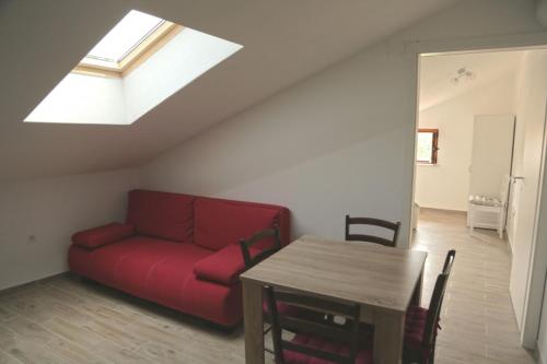 苏萨克Apartment in Susak with air conditioning, W-LAN (3865-6)的客厅配有红色的沙发和桌子