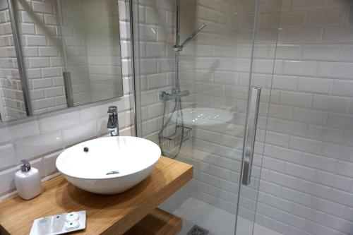 塔皮亚德卡萨列戈Apartamentos Turísticos El Peñón的白色的浴室设有水槽和淋浴。