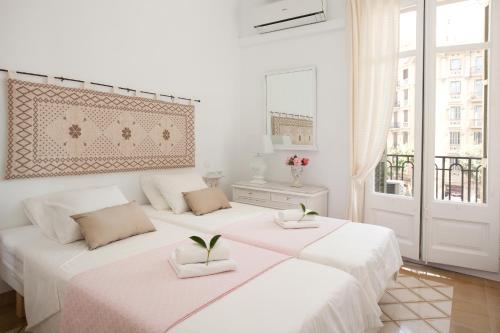 巴塞罗那穆塔纳尔酒店的白色房间设有两张床,上面有植物