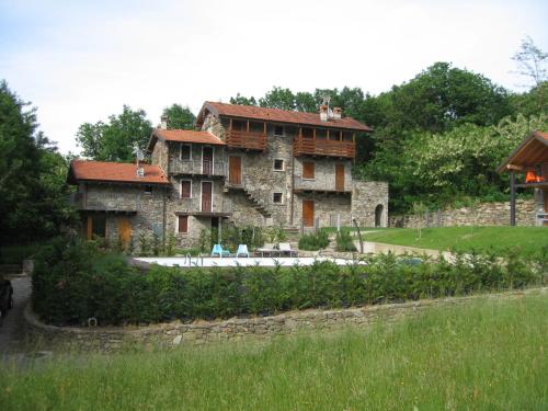 科利科Casale Antico Borgo的一座大型石头建筑,前面设有一个游泳池