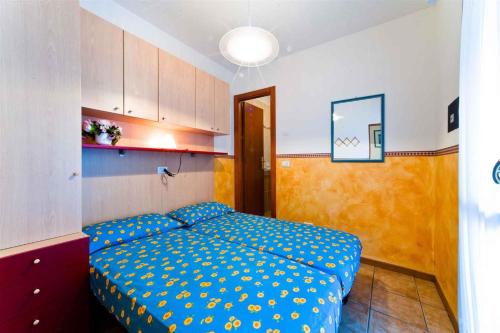 比比翁Apartment in Bibione 24426的一间卧室配有一张带蓝色棉被的床