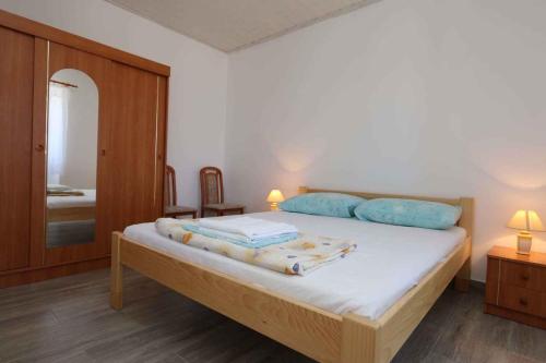 希洛Apartment in Silo/Insel Krk 13441的一间卧室配有一张带蓝色枕头和镜子的床