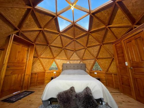 瓜塔维塔GLAMCAPTOUR的大型木制客房内的一间卧室配有一张床
