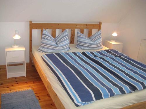 DändorfApartment in Dierhagen (Ostseebad) 2646的一间卧室配有一张带蓝色和白色条纹枕头的床