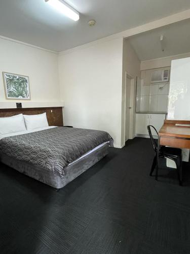 CondobolinAllambie Motel的一间卧室配有一张床、一张桌子和一张书桌