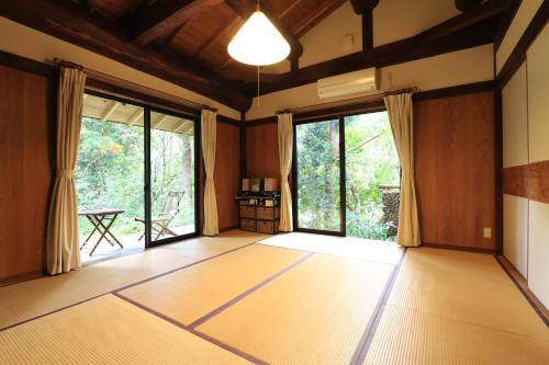 屋久岛和之小屋 仙之家的空空房间,设有木地板和大窗户