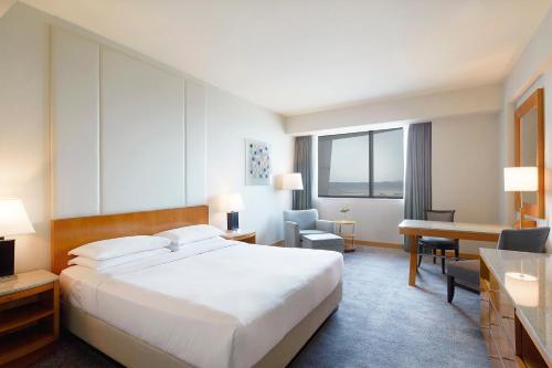仁川市仁川凯悦大酒店的酒店客房设有一张大床和一张书桌。