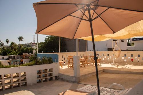 圣何塞德尔卡沃Hotel Casa Ceci Inn的庭院配有遮阳伞和桌椅。