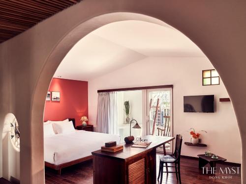 胡志明市东桂神秘岛酒店的配有一张床、一张书桌和一扇窗户的酒店客房