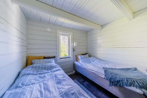 TorskenSenja Fjordcamp的白色墙壁客房的两张床