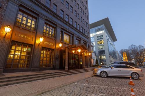 第聂伯罗阿克赛尔霍夫精品酒店的停在大楼前的街道上的汽车