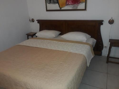 蒂米什瓦拉朱利亚酒店的一间卧室配有一张带木制床头板的床