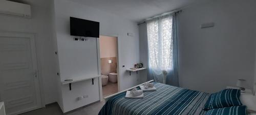 马纳罗拉Olimpo Affittacamere的一间卧室配有一张床、一台电视和一间浴室。