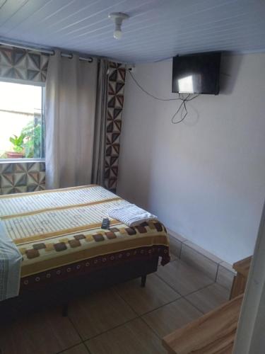 沙佩科JH santos的卧室配有一张床,墙上配有电视。