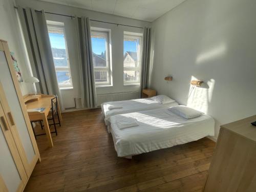 皮耶塔尔萨里Jugend Boutique Guesthome的一间卧室设有两张床、一张桌子和窗户。