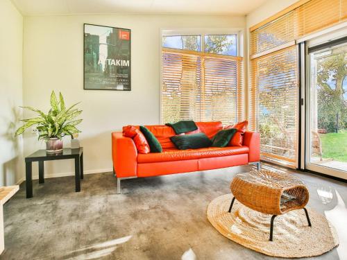 TripscompagnieFantastic modern vacation home with views的客厅里设有橙色沙发,配有窗户
