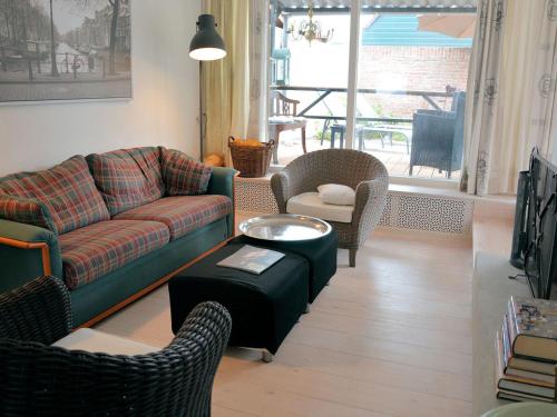 诺德克豪特Lovely Holiday Home in Noordwijkerhout near Lake的客厅配有沙发、椅子和桌子
