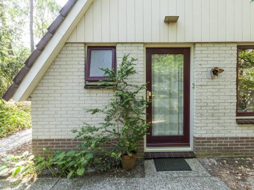 宁斯佩特Comfortable holiday home in Nunspeet的门前有一扇门和一棵树的房子