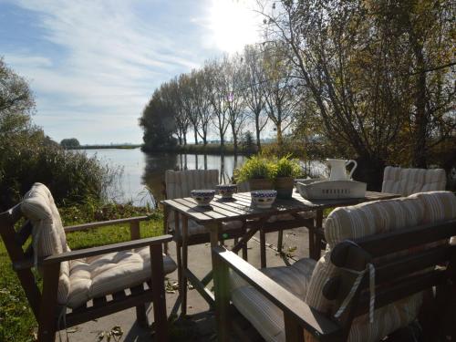 Hooge ZwaluwePicturesque Holiday Home in Drimmelen with Garden的桌椅,享有湖景