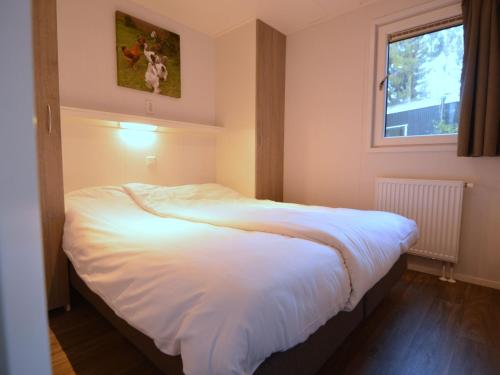 福尔登Nice chalet with dishwasher and wooded location的卧室配有一张大白色床和窗户