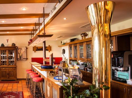 Mettingen贝尔吉斯霍赫酒店餐厅的一间酒吧,在房间里设有红色凳子