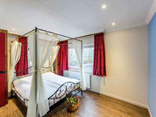 德布尔特Designed home with bedstead, surrounded by forest的一间卧室配有一张带红色窗帘的天蓬床