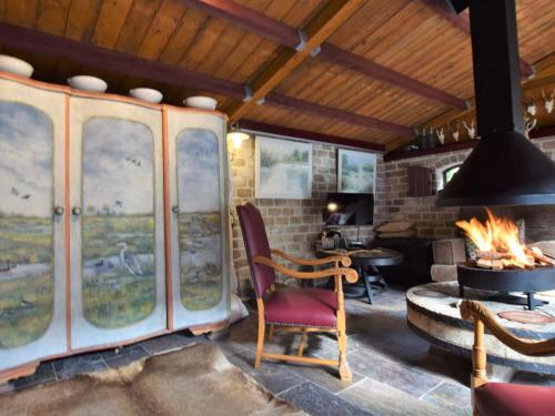 MusselkanaalCozy holiday home with a hot tub的客房设有壁炉、椅子和桌子。