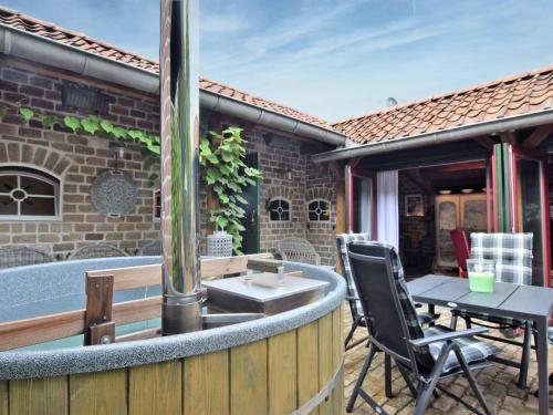 MusselkanaalCozy holiday home with a hot tub的庭院设有热水浴池、桌子和椅子。